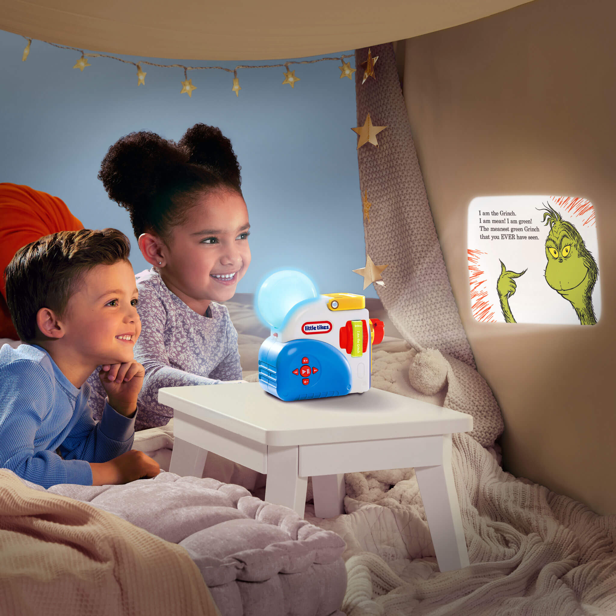Two children sitting in a cozy room with a night light and a book.