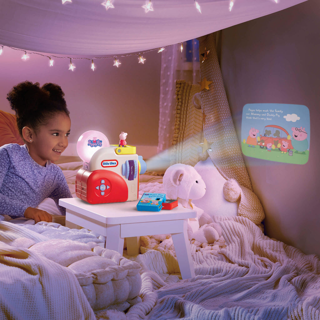 Child watching Peppa Pig on the wall in a cozy room with string lights.